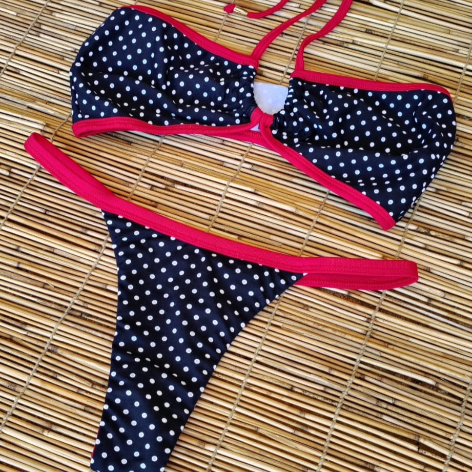 Polka dot bikini set with red straps on a woven mat