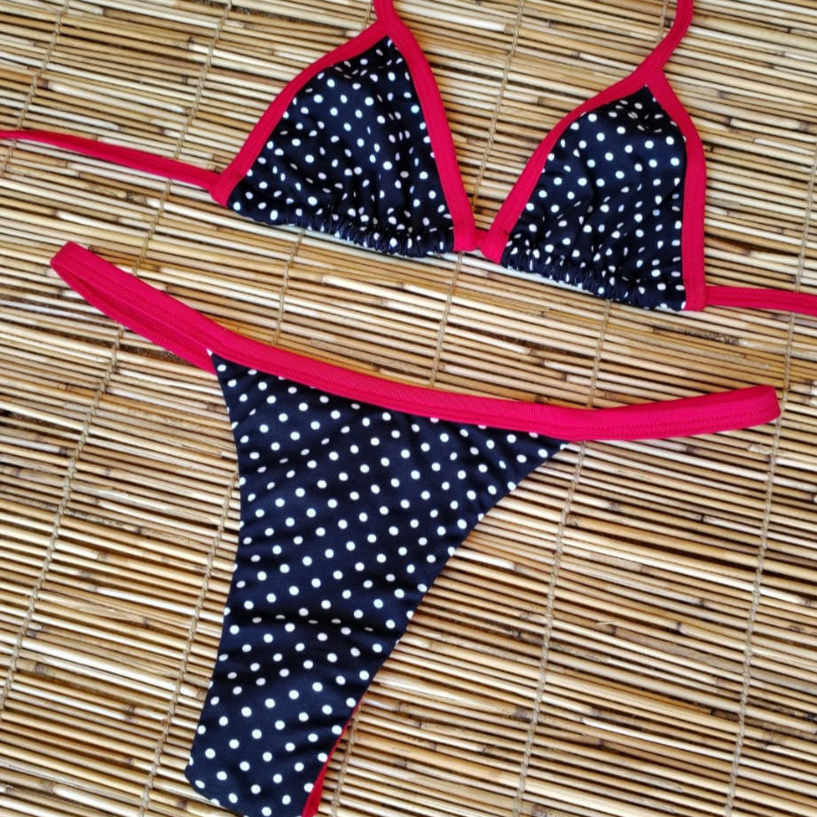 Polka dot bikini with red straps on a woven mat